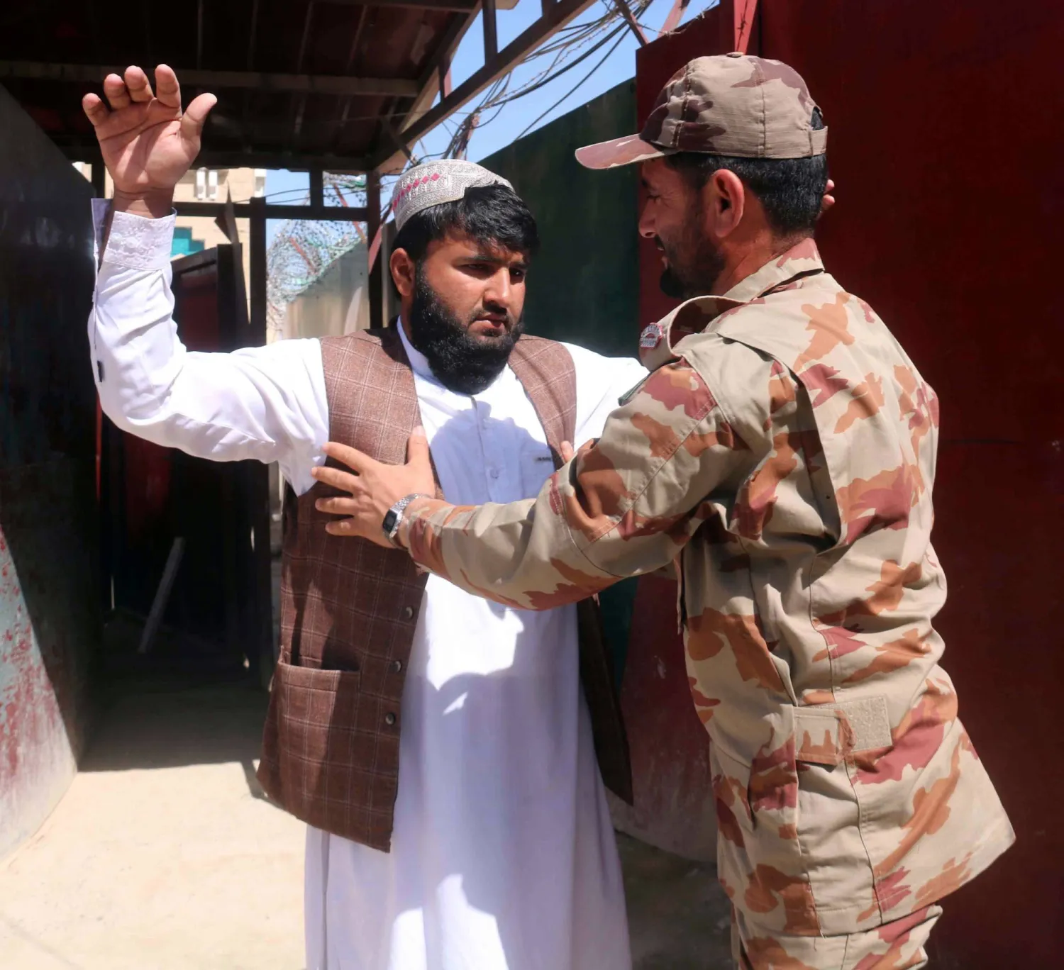 جندي باكستاني يفتش شخصاً أثناء الدخول عند الحدود الباكستانية الأفغانية في تشامان باكستان الثلاثاء (إ.ب.أ)