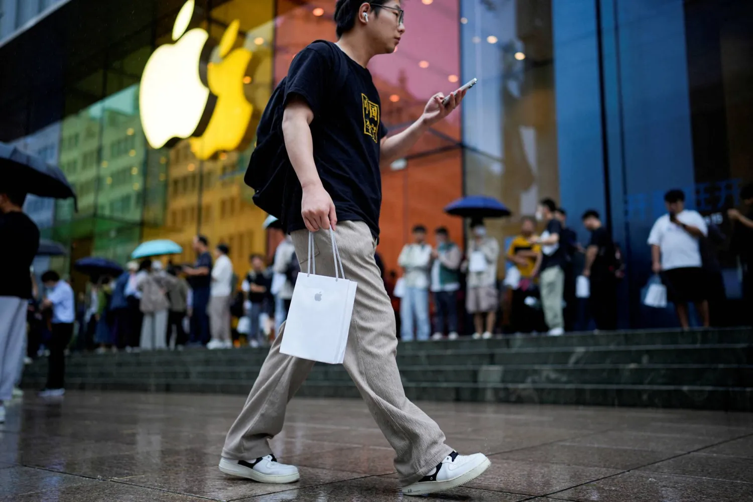 FILE PHOTO: A man holds a bag with a new iPhone inside it in Shanghai, China September 22, 2023. REUTERS/Aly Song/File Photo