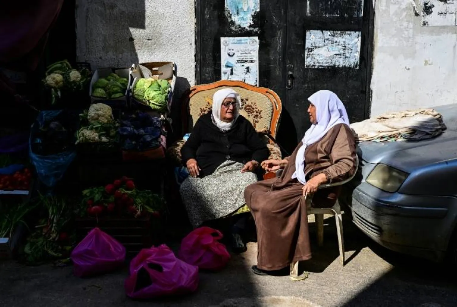 A Palestinian vendor chatting with a customer in Jenin refugee camp during the Muslim fasting month of Ramadan - AFP