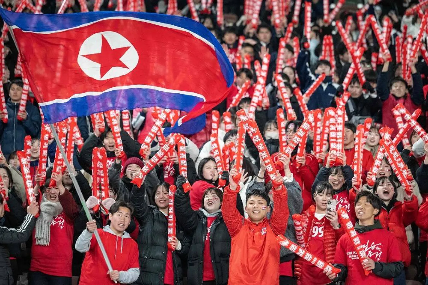 North Korea's fans cheer before the World Cup 2026 qualifier football match between Japan and North Korea at Tokyo's National Stadium on March 21, 2024. (AFP)