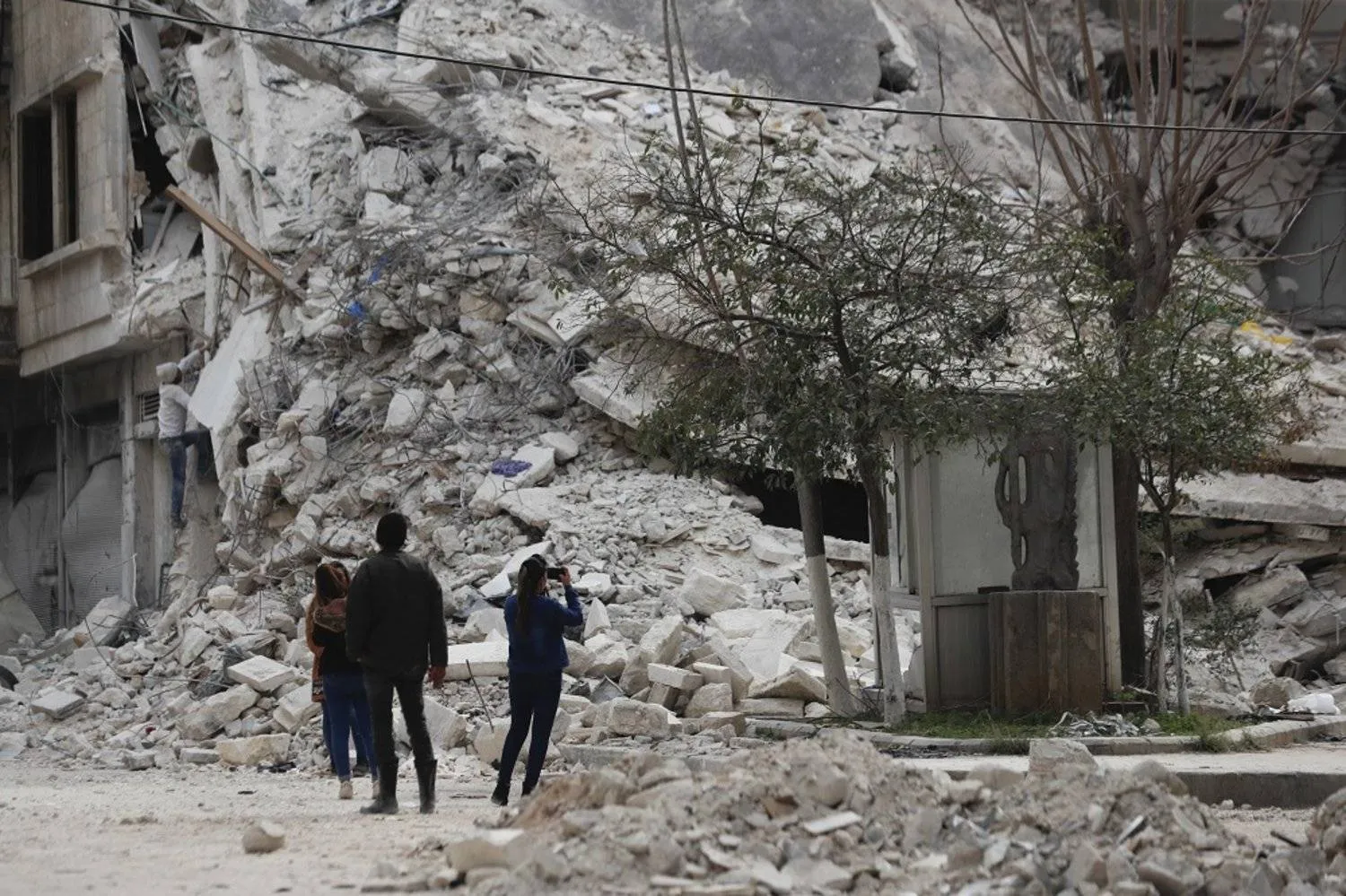 People stand by a building destroyed in recent earthquake in Aleppo, Syria, Monday, Feb. 27, 2023. (AP)
