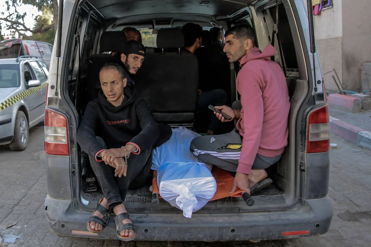 فلسطينيون ينقلون جثة شخص قُتل في قصف إسرائيلي من مشرحة مستشفى الشفاء بغزة (أ.ف.ب)