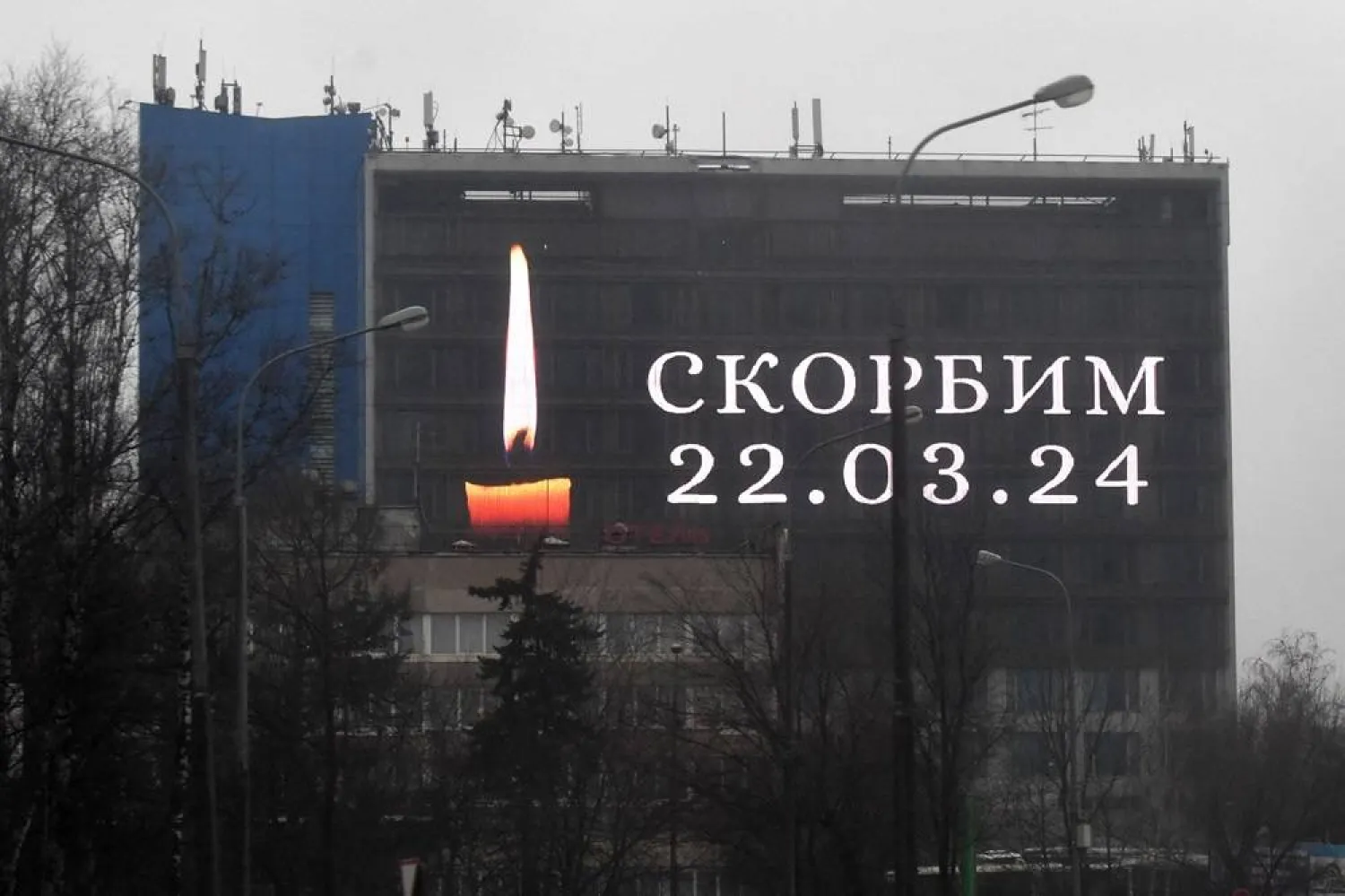 An advertising screen on the facade of a building displays an image of a lit candle and the slogan "(We) Mourn" in memory of victims of the concert hall gun attack in Moscow on March 23, 2024. (AFP)