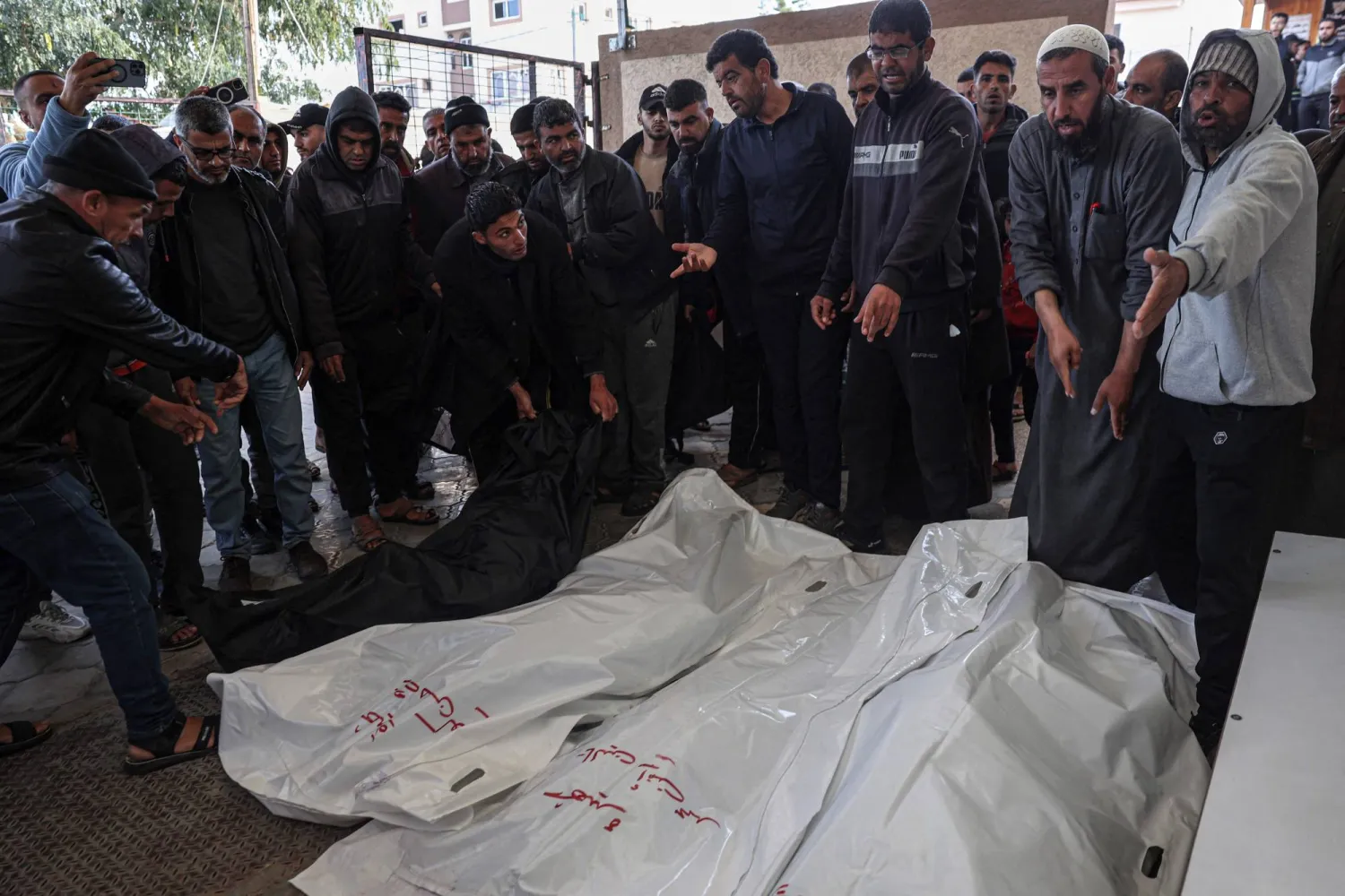 فلسطينيون يتجمعون حول جثث أقاربهم الذين قُتلوا بقصف إسرائيلي في مشرحة المستشفى الأوروبي بخان يونس (أ.ف.ب)