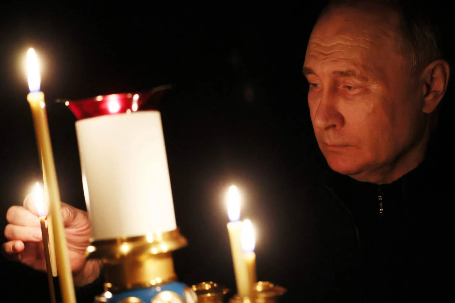 In this pool photograph distributed by the Russian state agency Sputnik, Russia's President Vladimir Putin lights a candle during his visit to a church of the Novo-Ogaryovo state residence outside Moscow on March 24, 2024, during a national day of mourning following the attack in the Crocus City Hall. (Photo by Mikhail METZEL / POOL / AFP)