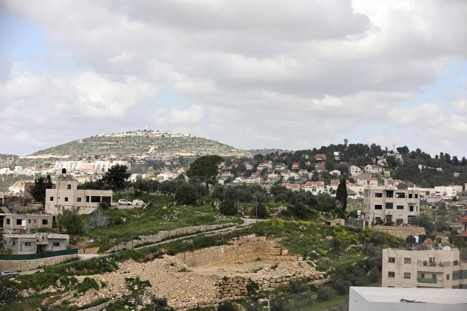 This photo taken from the Palestinian village of Dayr Ibzii west of Ramallah, shows the Israeli settlement of Dolev on the hill (R) in the occupied West Bank on March 22, 2024. (Photo by Zain JAAFAR / AFP)