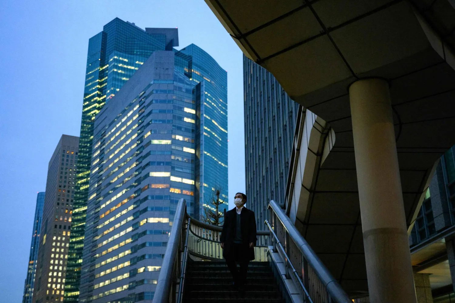 أحد المشاة في الحي المالي للعاصمة اليابانية طوكيو (أ.ف.ب)