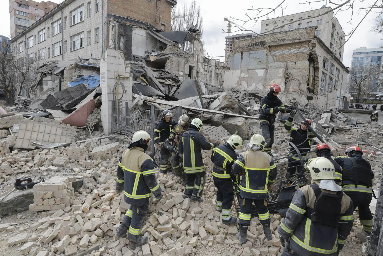 عناصر من الدفاع المدني تعمل في موقع استهدفه صاروخ في كييف الاثنين (إ.ب.أ)