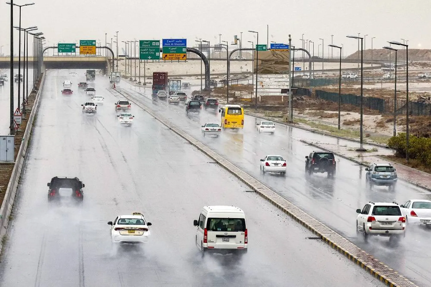 Vehicles move through mist and rain along a highway in Kuwait City on March 19, 2024. (AFP)