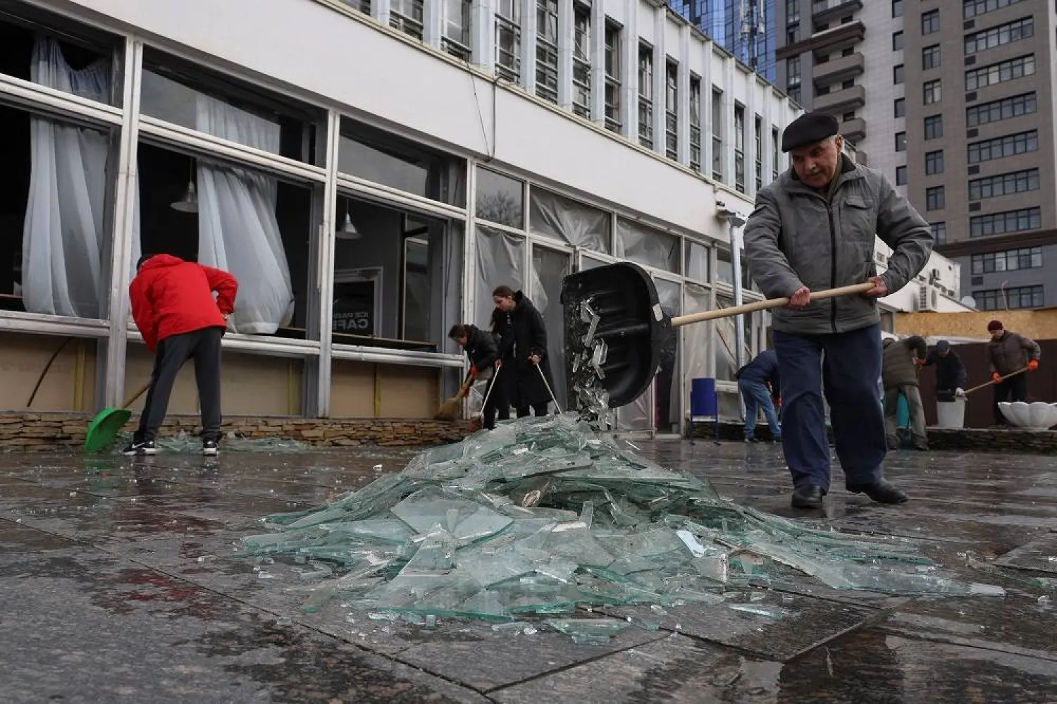 Local residents collect glass from broken windows at a site of a Russian missile strike, amid Russia's attack on Ukraine, in Odesa, Ukraine March 26, 2024. (Reuters)