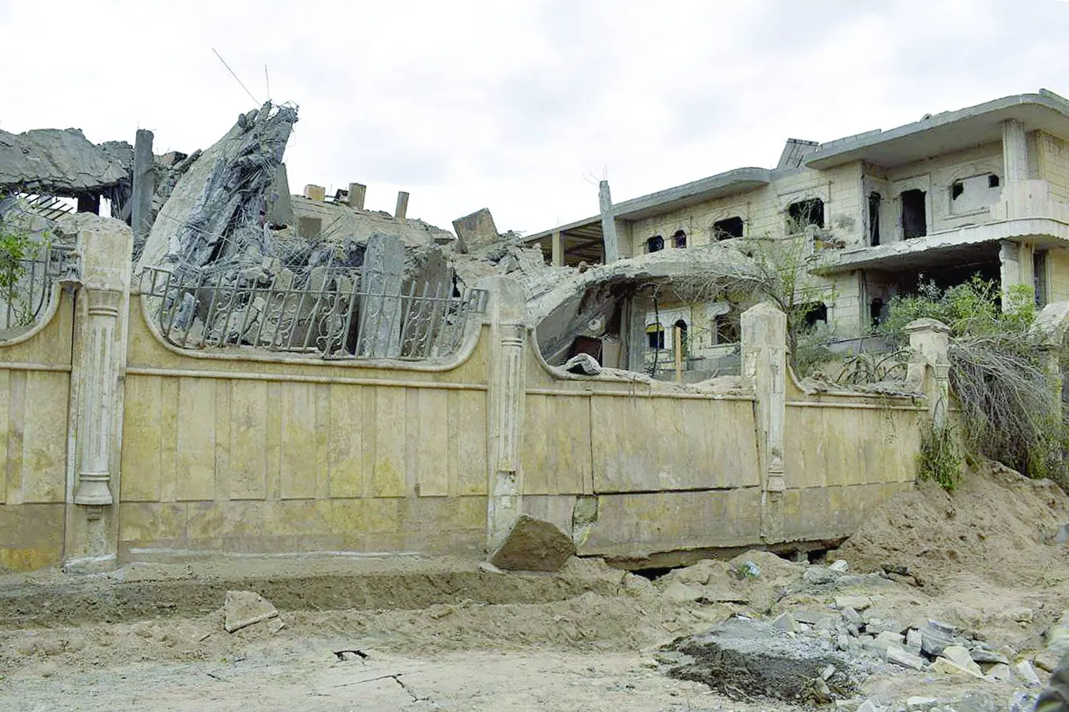 
مبنى متضرر بعد غارة جوية على مدينة دير الزور شرق سوريا طالت مواقع لـ«الحرس الثوري» الإيراني (أ.ف.ب) وفي الإطار بهروز واحدي المستشار في «الحرس الثوري» الإيراني