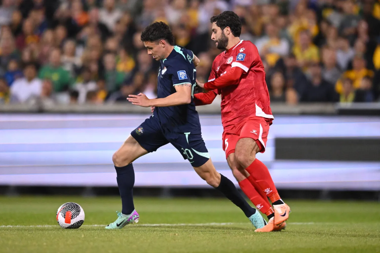 John Iredale (L) of Australia fights for the ball with Nassar Nassar of Lebanon during the FIFA World Cup 2026 AFC Asian Qualifiers match between Australia and Lebanon at GIO Stadium in Canberra, Australia, 26 March 2024.  EPA/LUKAS COCH   