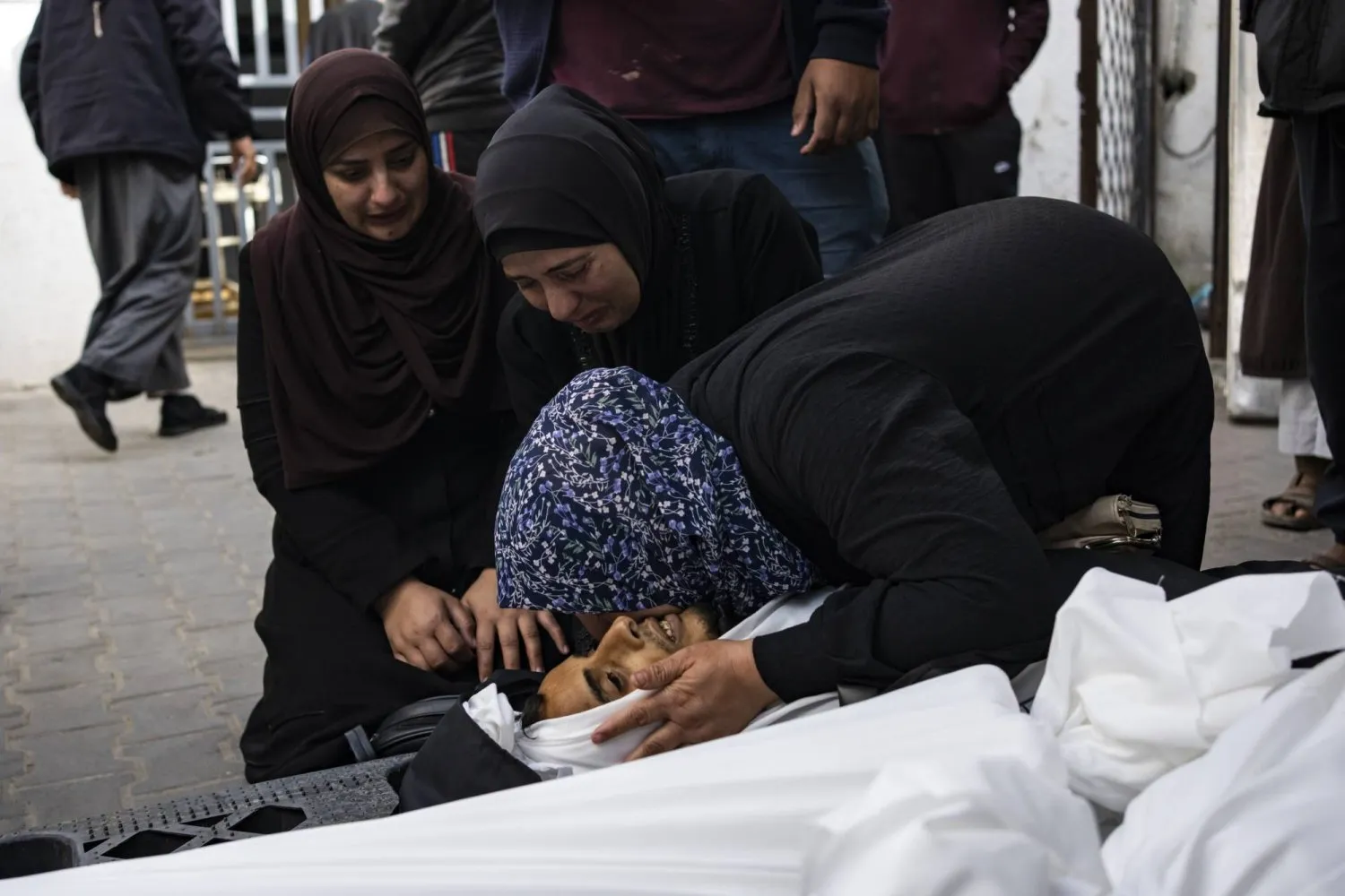 İsrail’in Refah’taki hava saldırısında ölen bir yakınına ağlayan kadınlar (AP)