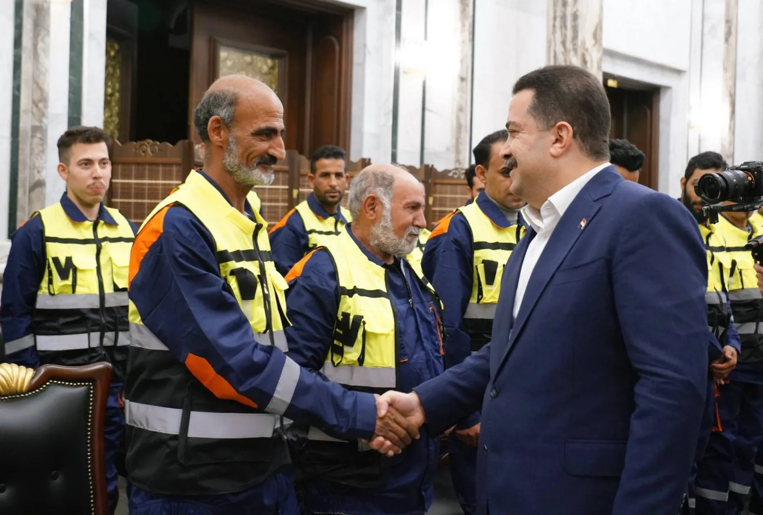 السوداني خلال لقائه عمال نظافة في بغداد خلال مأدبة رمضانية (إعلام حكومي)