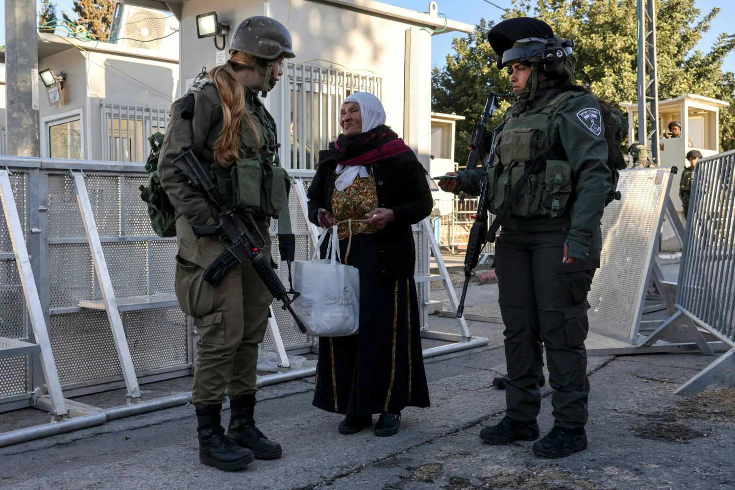 مسنة فلسطينية تتحدث لجنود إسرائيليين عند نقطة تفتيش في بيت لحم (ا.ف.ب)