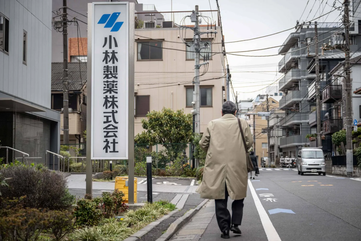A man walks past a signage of Kobayashi Pharmaceutical outside of the company's office in Tokyo on March 28, 2024. (Photo by Yuichi YAMAZAKI / AFP)