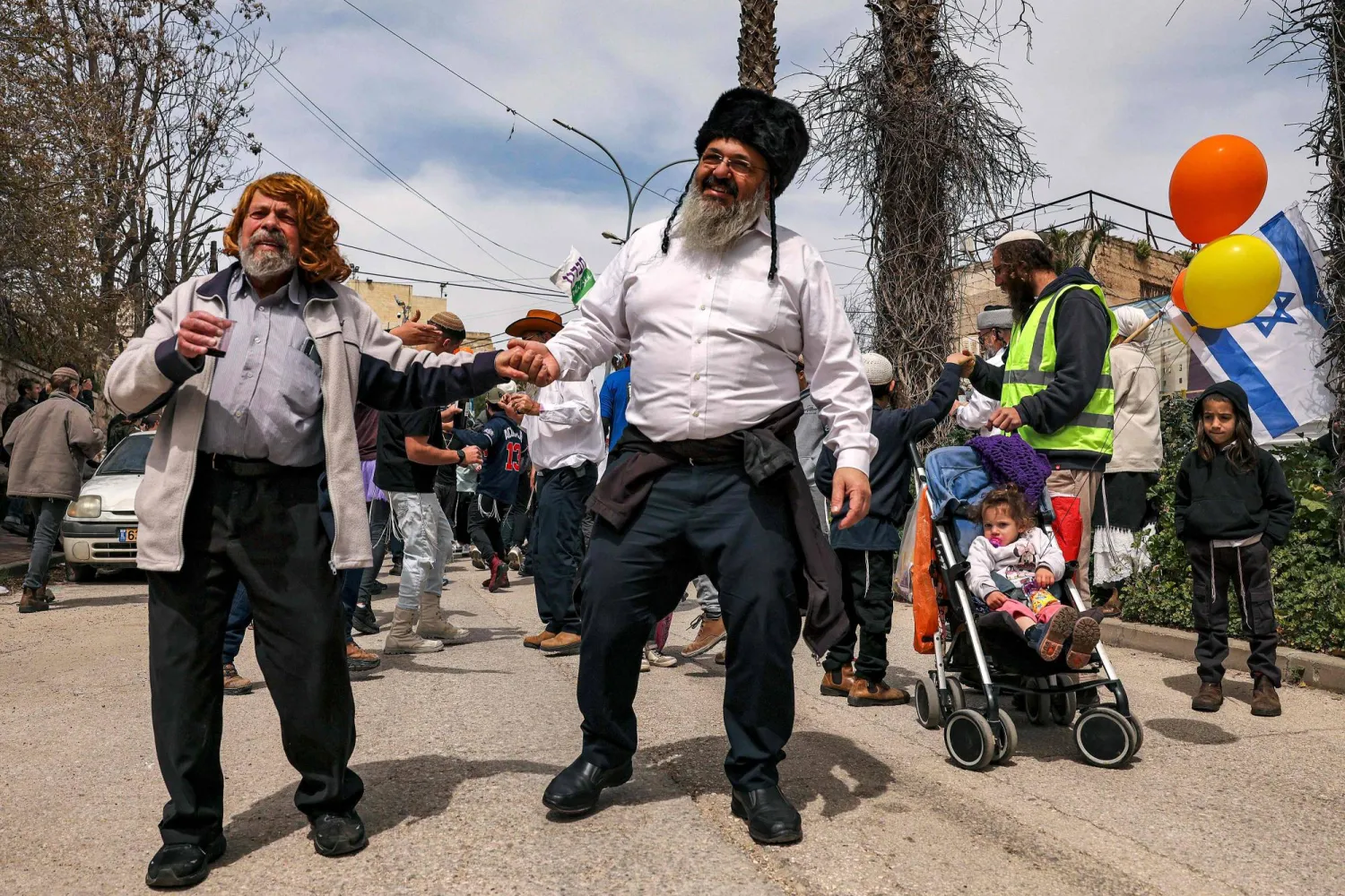 مستوطنون إسرائيليون في شارع الشهداء بالخليل خلال عيد البوريم 24 مارس (آذار) 2024 (أ.ف.ب)