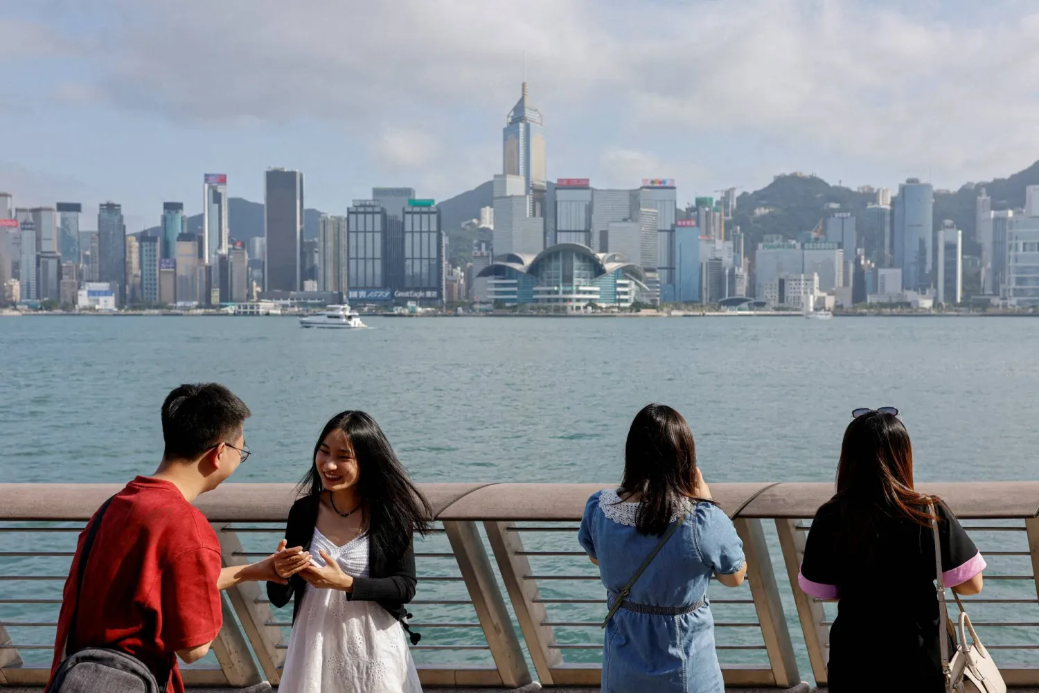 FILE PHOTO: Mainland Chinese tourists take photo of the skyline of buildings at Tsim Sha Tsui in Hong Kong, China, May 2, 2023. REUTERS/Tyrone Siu/File Photo