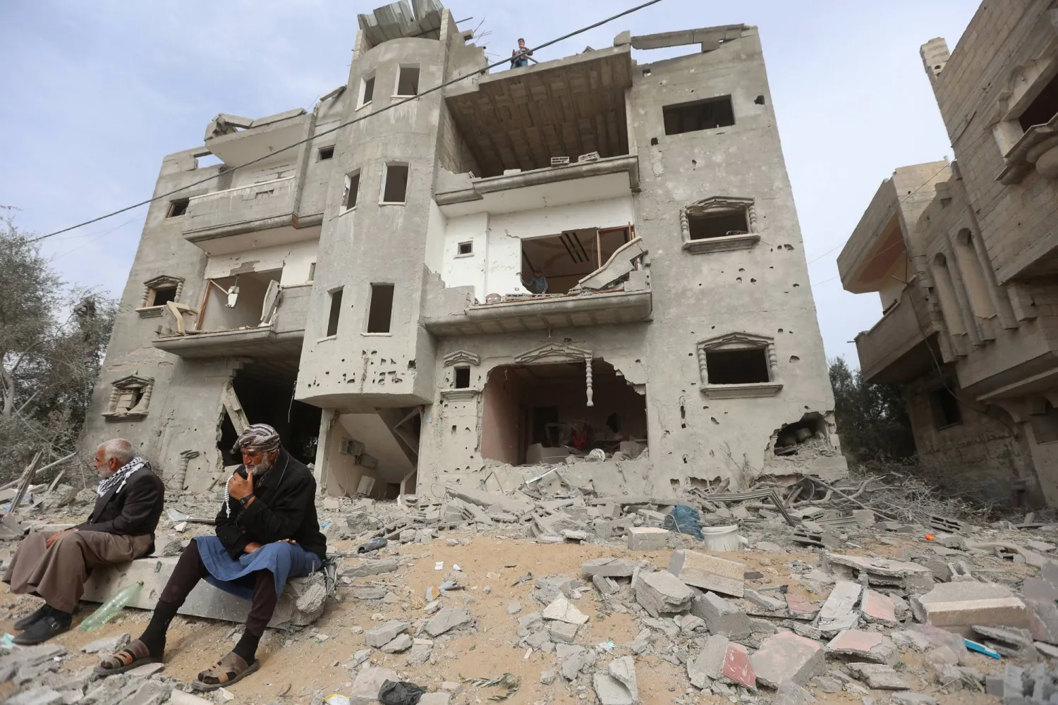 فلسطينيون يتجمعون في موقع غارة إسرائيلية على منزل بخان يونس وسط الحرب المستمرة (رويترز)