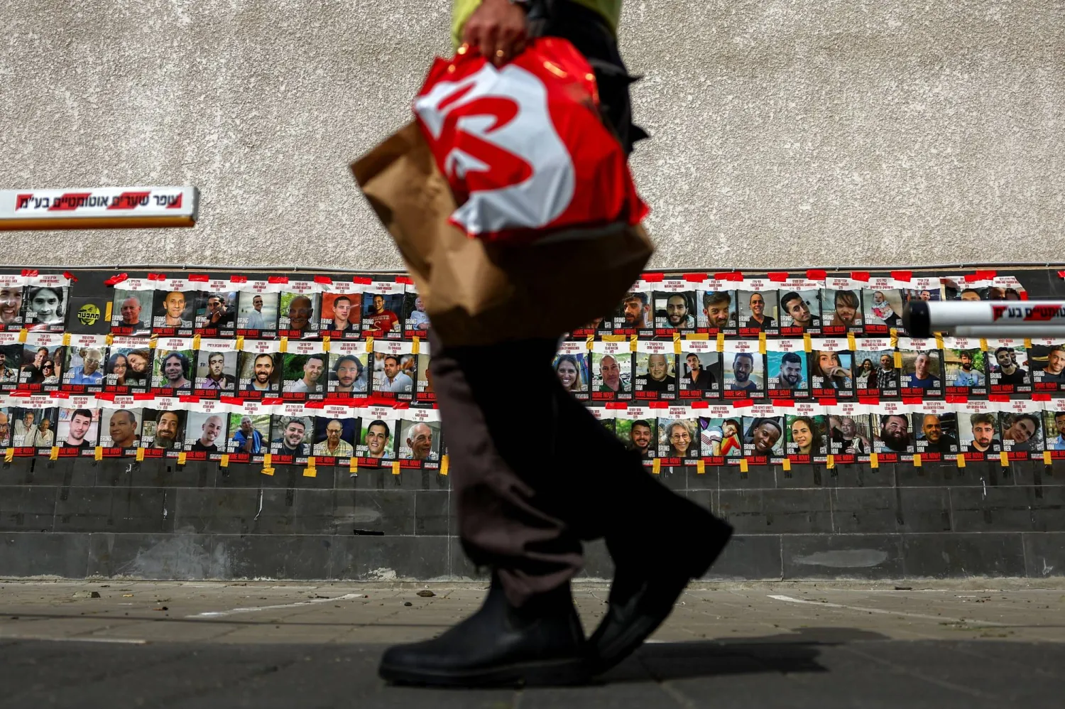 صور محتجزين إسرائيليين لدى حركة «حماس» على جدار في تل أبيب اليوم السبت (رويترز)