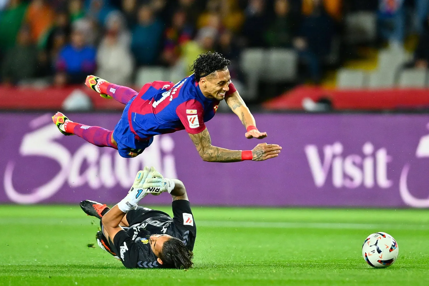 رافينيا صاحب هدف الفوز الكاتالوني الوحيد يتعرض للسقوط بعد احتكاكه بحارس بالماس (أ.ف.ب)