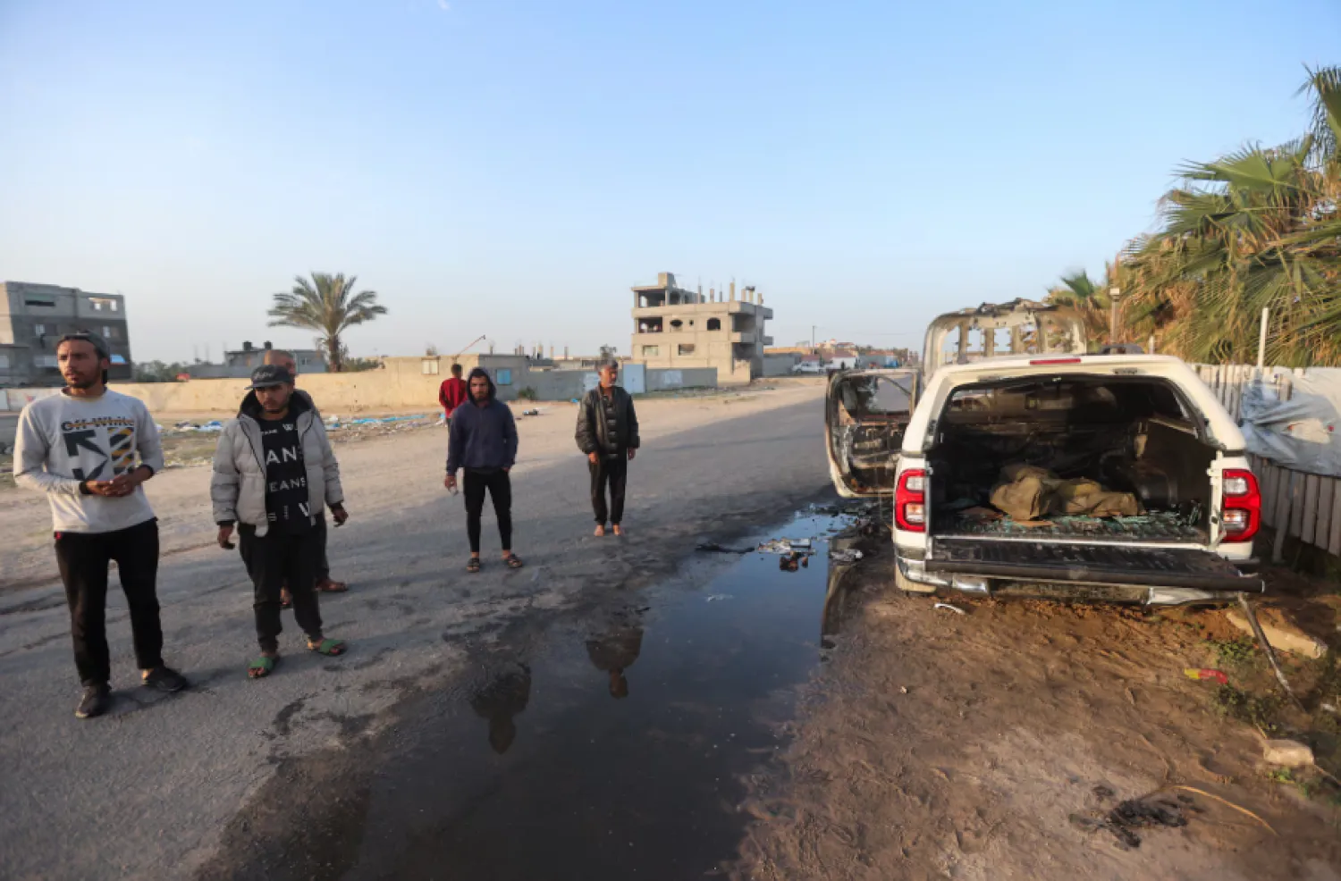 Palestinians stand next to a vehicle where employees from the World Central Kitchen (WCK) were killed in an Israeli airstrike, in Deir Al-Balah, Gaza, April 2. - Reuters