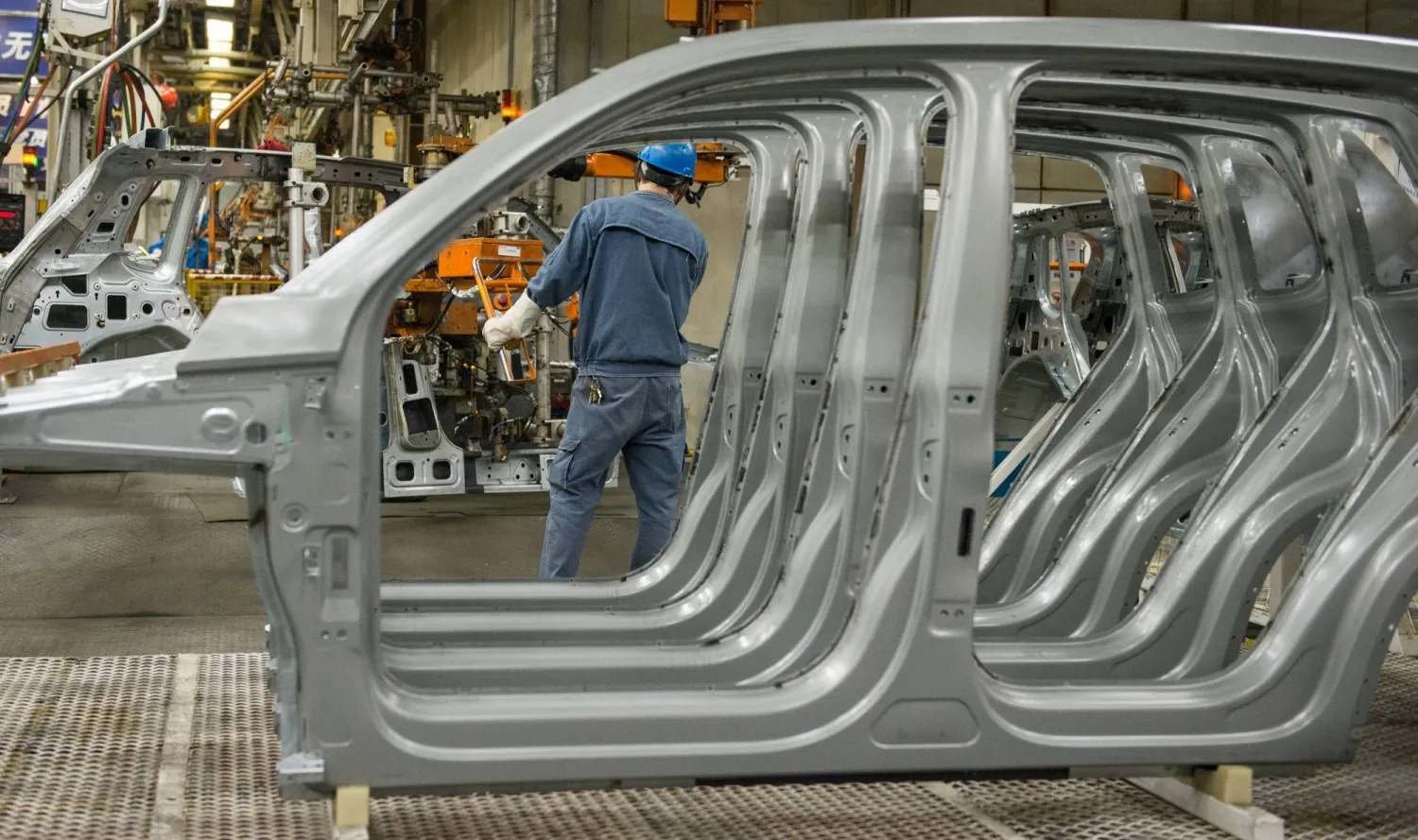 عامل في أحد مصانع السيارات التابعة لـ«فولكسفاغن» قرب مدينة شنغهاي الصينية (د.ب.أ)