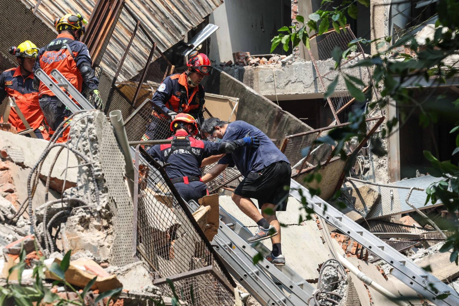 تظهر هذه الصورة التي التقطتها «وكالة الأنباء المركزية التايوانية (CNA)» في 3 أبريل 2024 عمال الطوارئ وهم يساعدون أحد الناجين بعد أن جرى إنقاذه من مبنى متضرر بمدينة تايبيه الجديدة بعد أن ضرب زلزال كبير شرق تايوان (أ.ف.ب)
