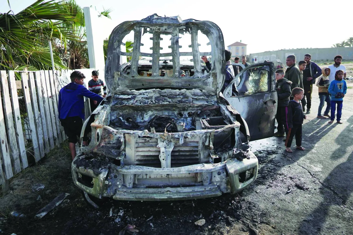 People gather around the car of the US-based aid group World Central Kitchen that was hit by an Israeli strike the previous day in Deir al-Balah in the central Gaza Strip on April 2, 2024, amid the ongoing battles between Israel and the Palestinian group Hamas. (Photo by AFP)