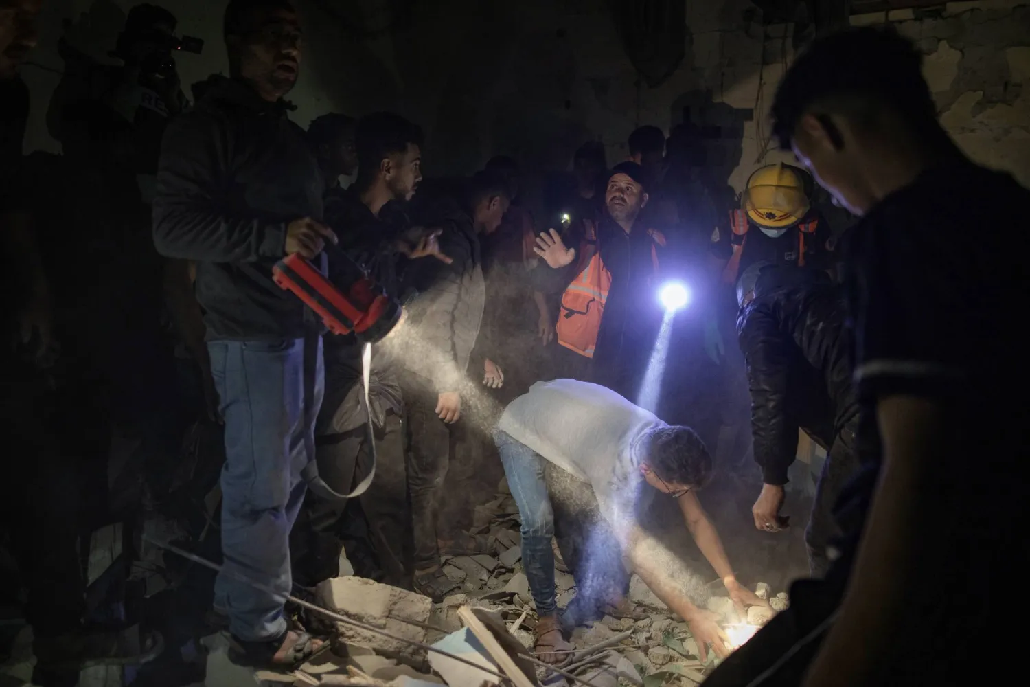 فلسطينيون يبحثون عن مفقودين تحت أنقاض منزل في أعقاب غارة جوية إسرائيلية على مخيم رفح للاجئين (د.ب.أ)