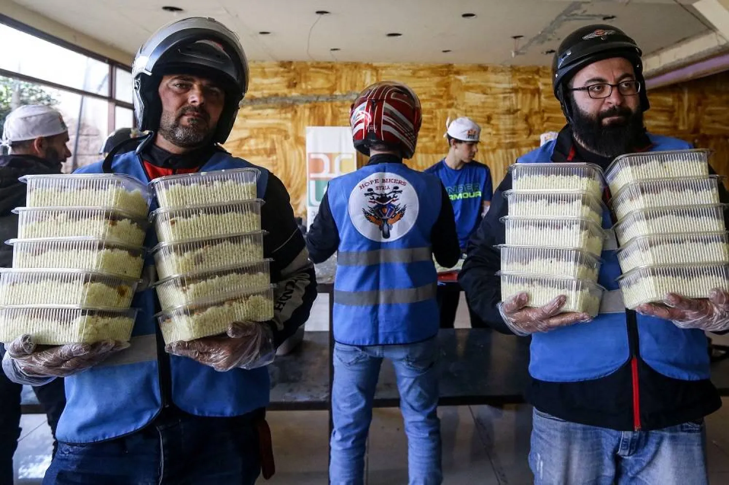 Members of motorcycle club Hope Bikers Syria help distribute "iftar" fast breaking meals during the Muslim holy fasting month of Ramadan, in Damascus on March 25, 2024. (AFP)
