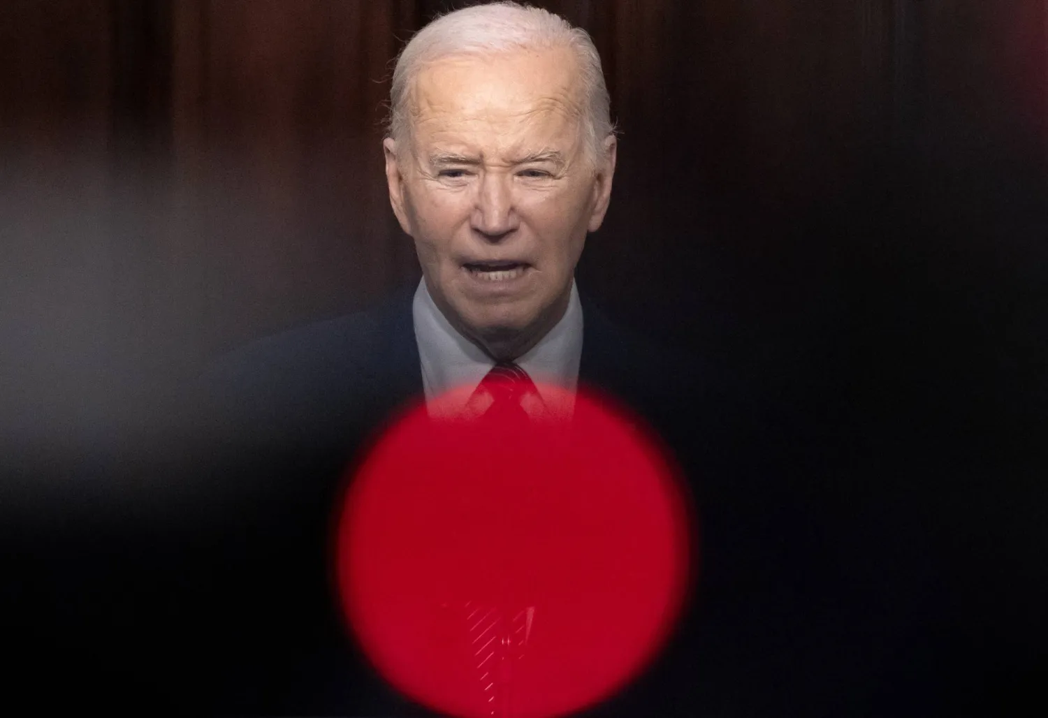 الرئيس الأميركي جو بايدن خلف ضوء أحمر من كاميرا تصوره في البيت الأبيض (إ.ب.أ)