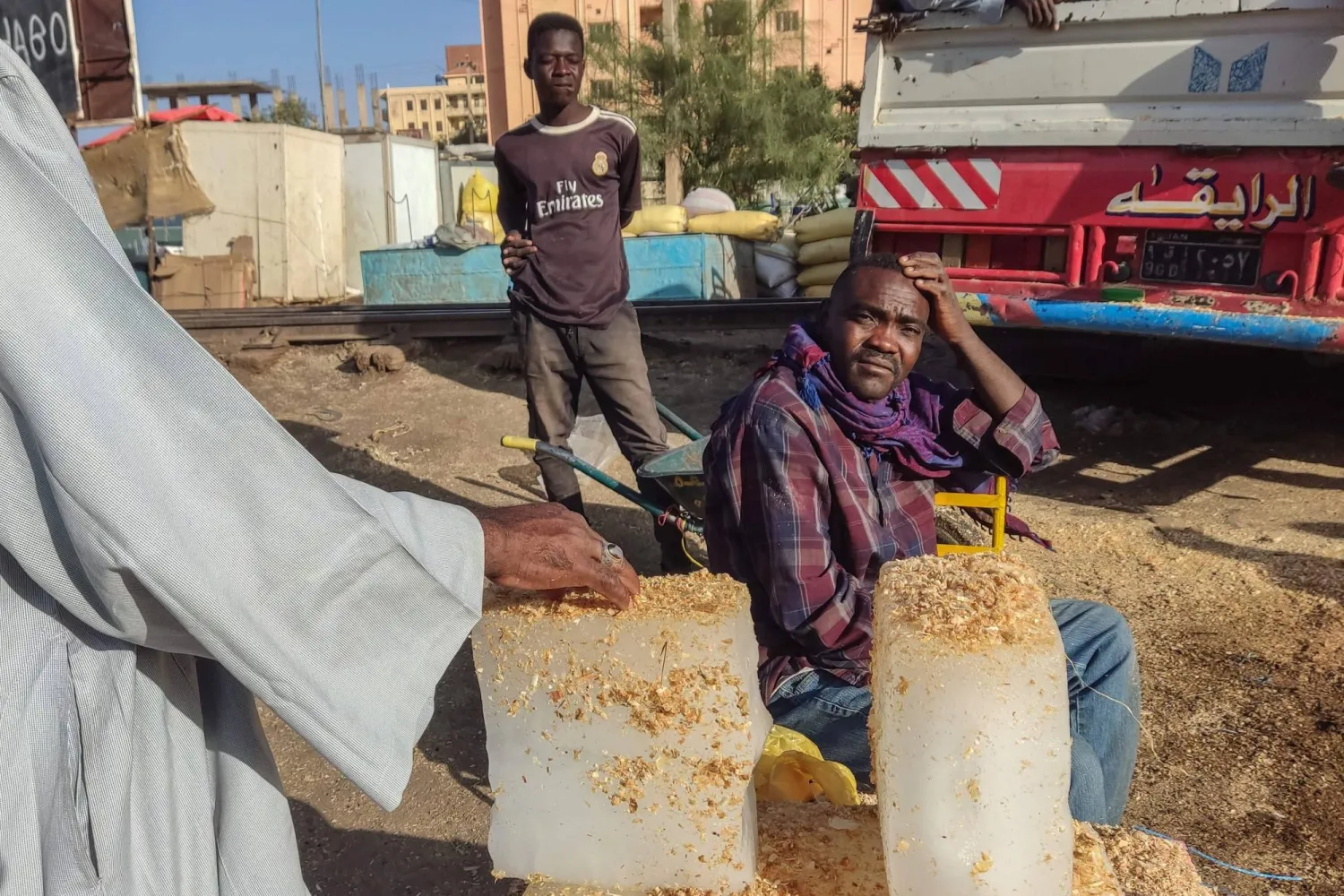 سوداني يبيع الثلج في ظل ارتفاع درجات الحرارة خلال شهر رمضان في القضارف (أ.ف.ب)