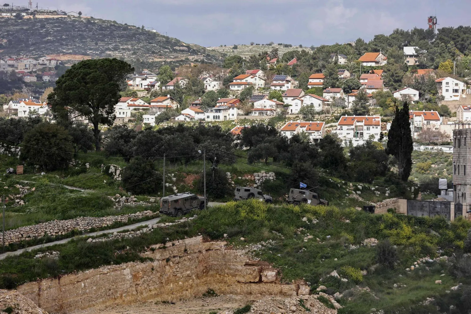 صورة من قرية فلسطينية تظهر مستوطنة دوليف المقامة على أراضي الضفة الغربية (أ.ف.ب)