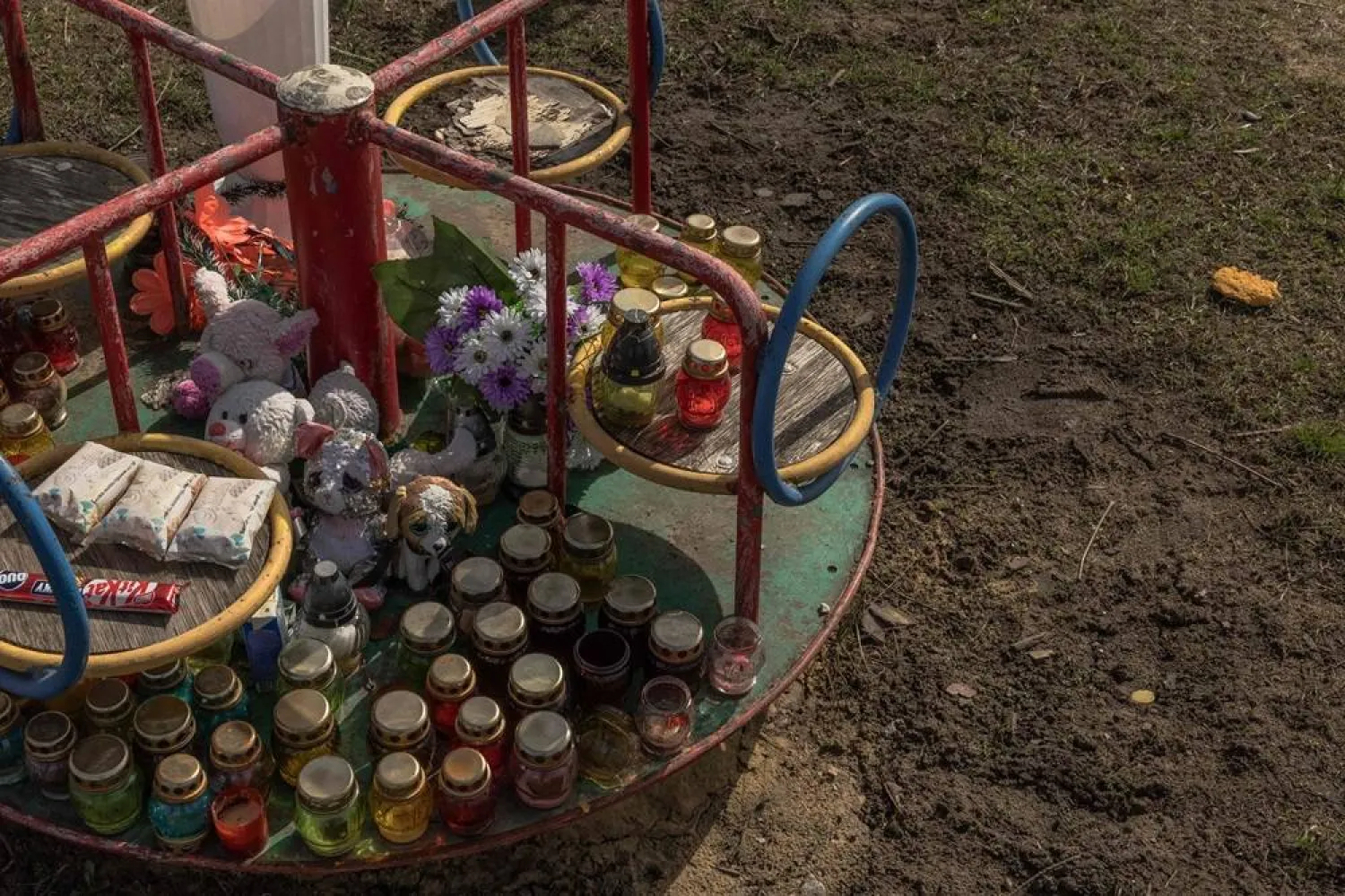 This photograph taken on March 31, 2024, shows candles and toys in memory of the victims at a playground at the site of the Russian strike that hit a cafe last year, in the village of Groza, Kharkiv region, amid the Russian invasion of Ukraine. (AFP)