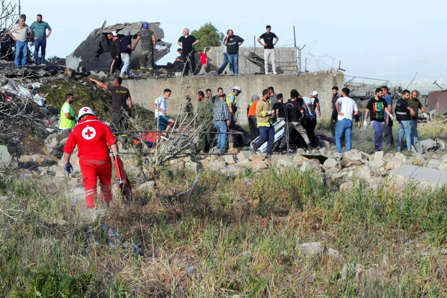 مسعفون ومواطنون يبحثون عن ناجين وقتلى تحت أنقاض أحد المنازل المدمرة نتيجة القصف الإسرائيلي في مرجعيون يوم الجمعة (أ.ف.ب)