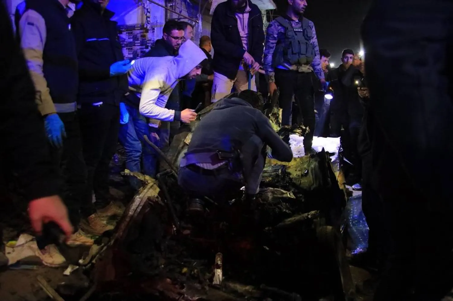 Rescuers check the wreckage of a car at the scene of a bomb explosion in Azaz, northern Syria, 31 March 2024. (EPA)