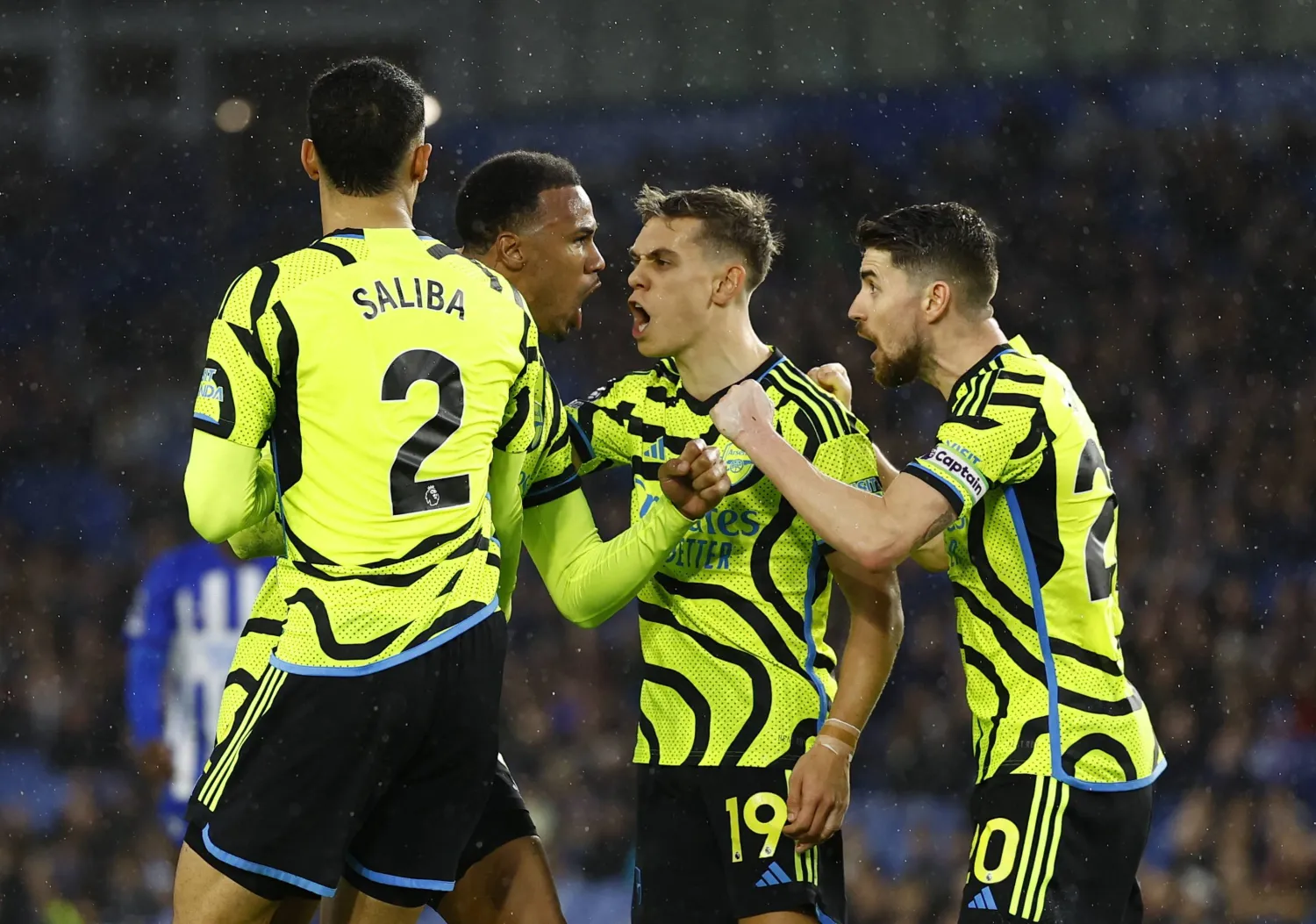 لاعبو آرسنال يحتفلون بهدفهم الثالث في برايتون (رويترز)