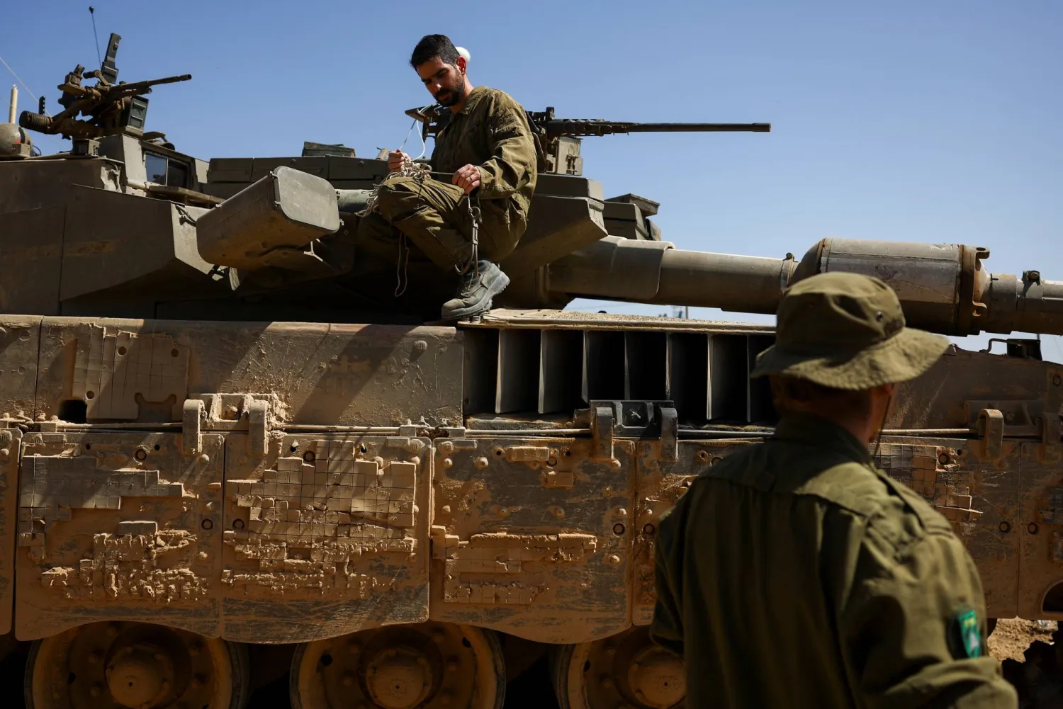 جنود إسرائيليون على دبابة من نوع «ميركافا» بالقرب من الحدود بين إسرائيل وغزة (رويترز)