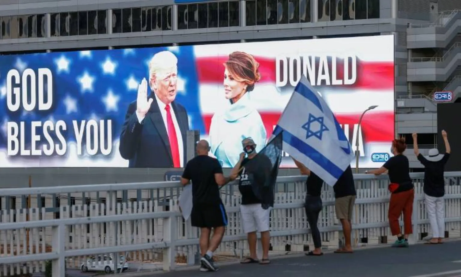 Then-US president Donald Trump and his wife Melania Trump are seen on a jumbo screen in Tel Aviv, Israel -- but lately, his level of support for Israel has been vague - AFP
