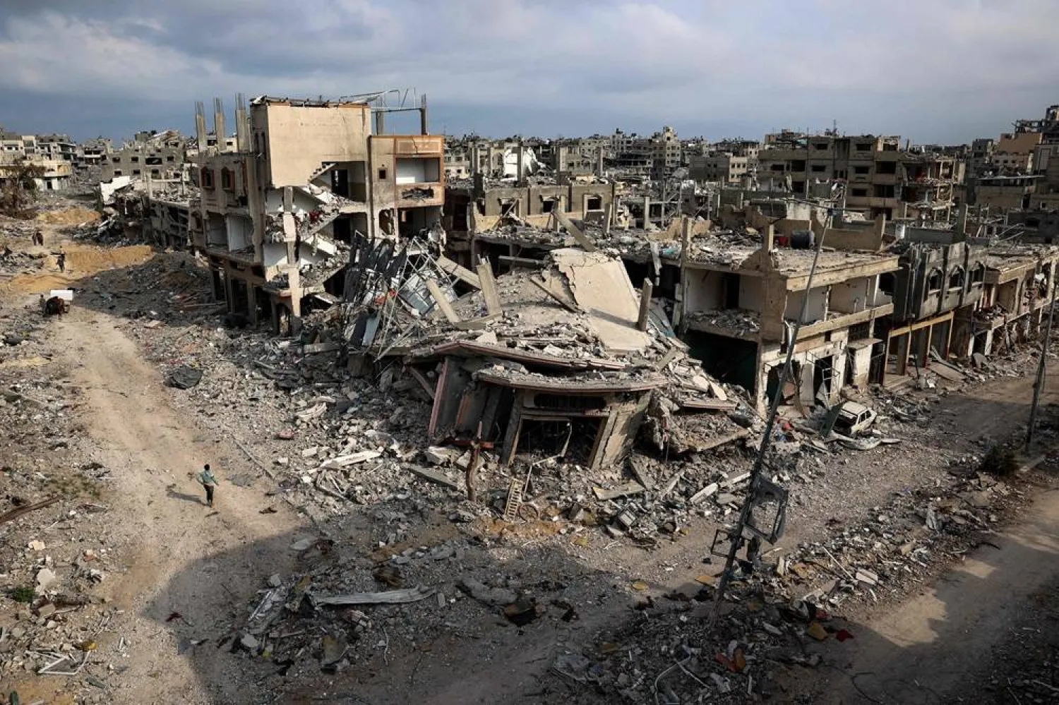  Palestinians walk past damaged buildings in Khan Younis on April 8, 2024 after Israel pulled its ground forces out of the southern Gaza Strip, six months into the devastating war sparked by the October 7 attacks. (AFP)