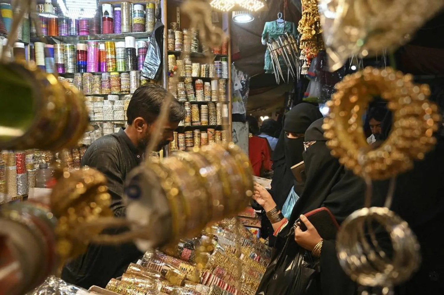  In this picture taken on March 31, 2024, customers buy bangles at a shop in Hyderabad. Layers of intricately decorated bangles are a staple fashion accessory for women in Pakistan, a carefully considered part of their Islamic Eid al-Fitr celebrations. (AFP)
