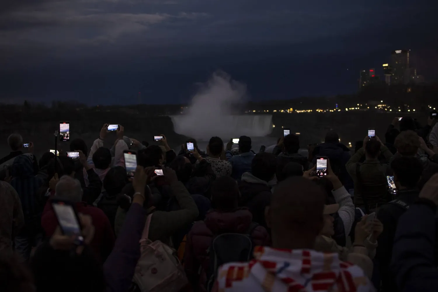 الزائرون يستخدمون هواتفهم لتوثيق كسوف الشمس الكلي من شلالات نياجرا (أ.ب)