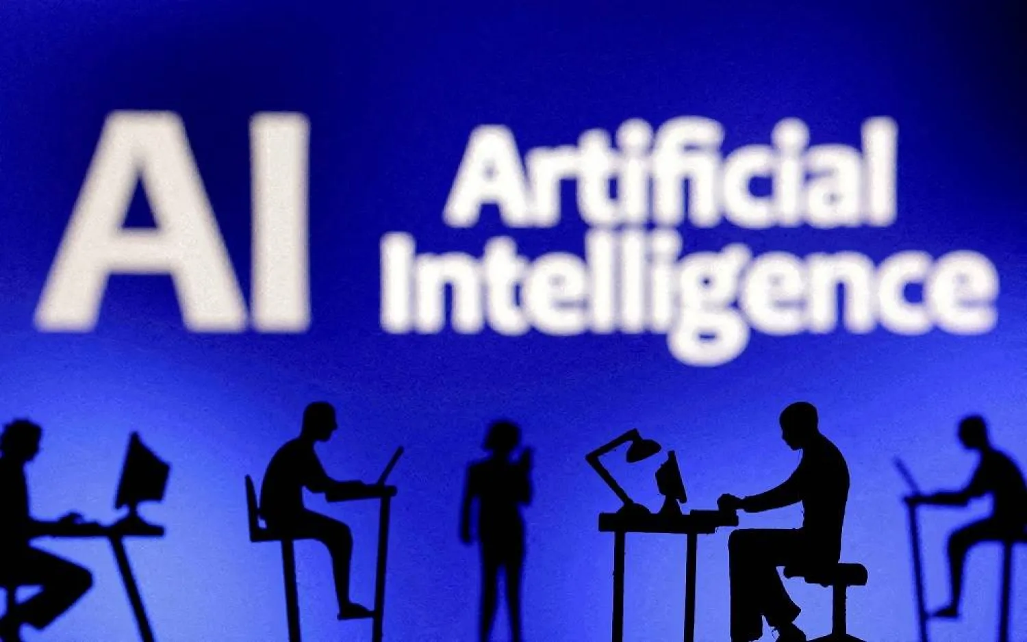 Figurines with computers and smartphones are seen in front of the words "Artificial Intelligence AI" in this illustration taken, February 19, 2024. (Reuters)