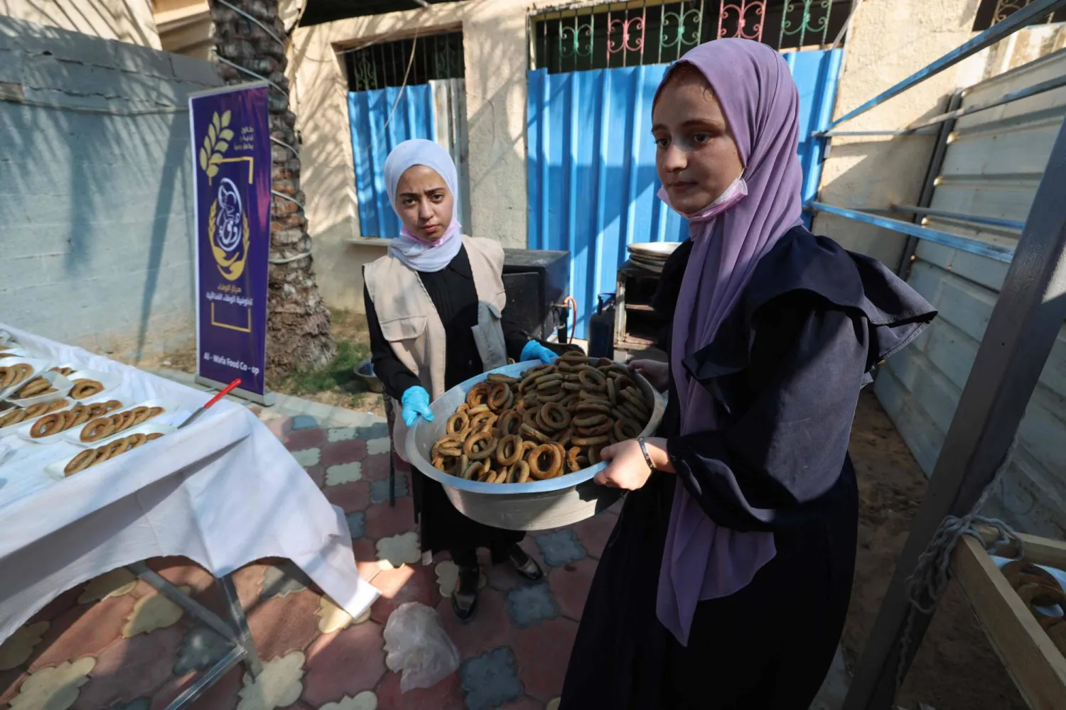 توزيع الكعك على النازحين للاحتفال بالعيد (أ.ف.ب)