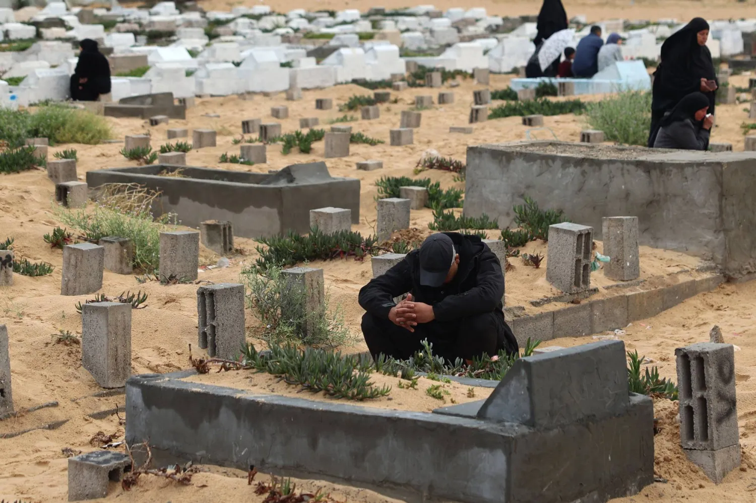 فلسطيني عند قبر أحد أقربائه قُتِل خلال الحرب في رفح جنوب غزة (أ.ف.ب)