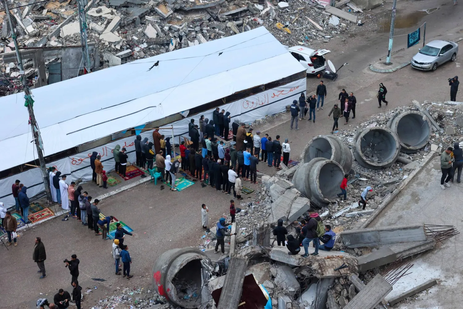 نازحون فلسطينيون يؤدون صلاة عيد الفطر خارج مسجد مدمر في رفح، جنوب قطاع غزة في 10 أبريل 2024 (أ.ف.ب)