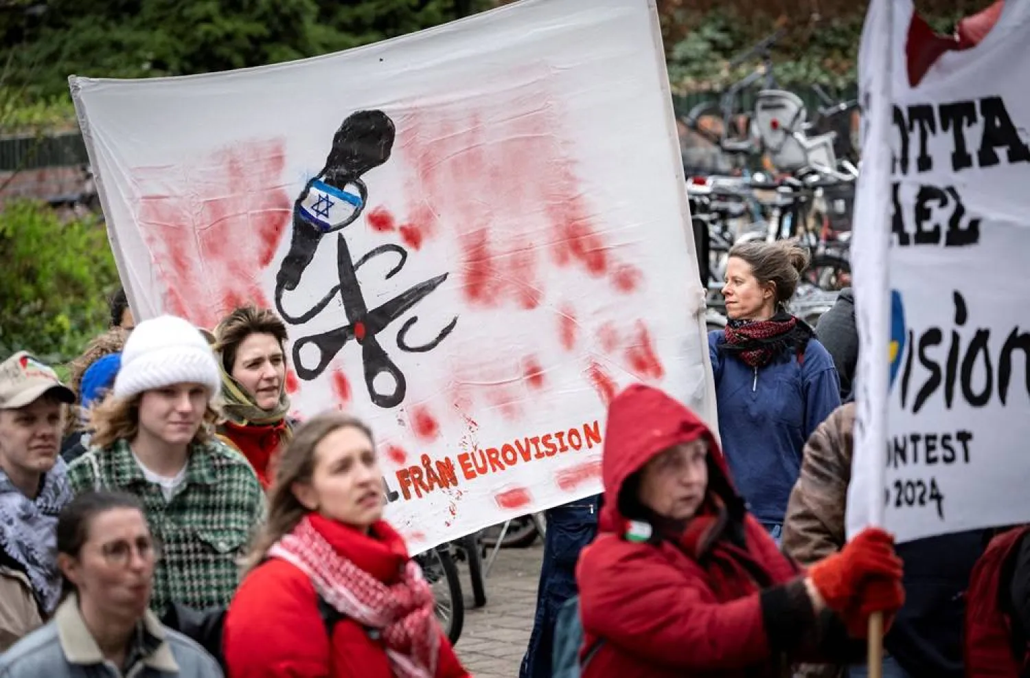 People hold banners at a demonstration in connection with the municipal board's consideration of a citizens' proposal by the initiative 'No Eurovision in Malmo with Israel's participation' to stop Israel's participation in Eurovision, outside the City Hall in Malmo, Sweden, April 10, 2024. (Johan NilssonTT News Agency/via Reuters)