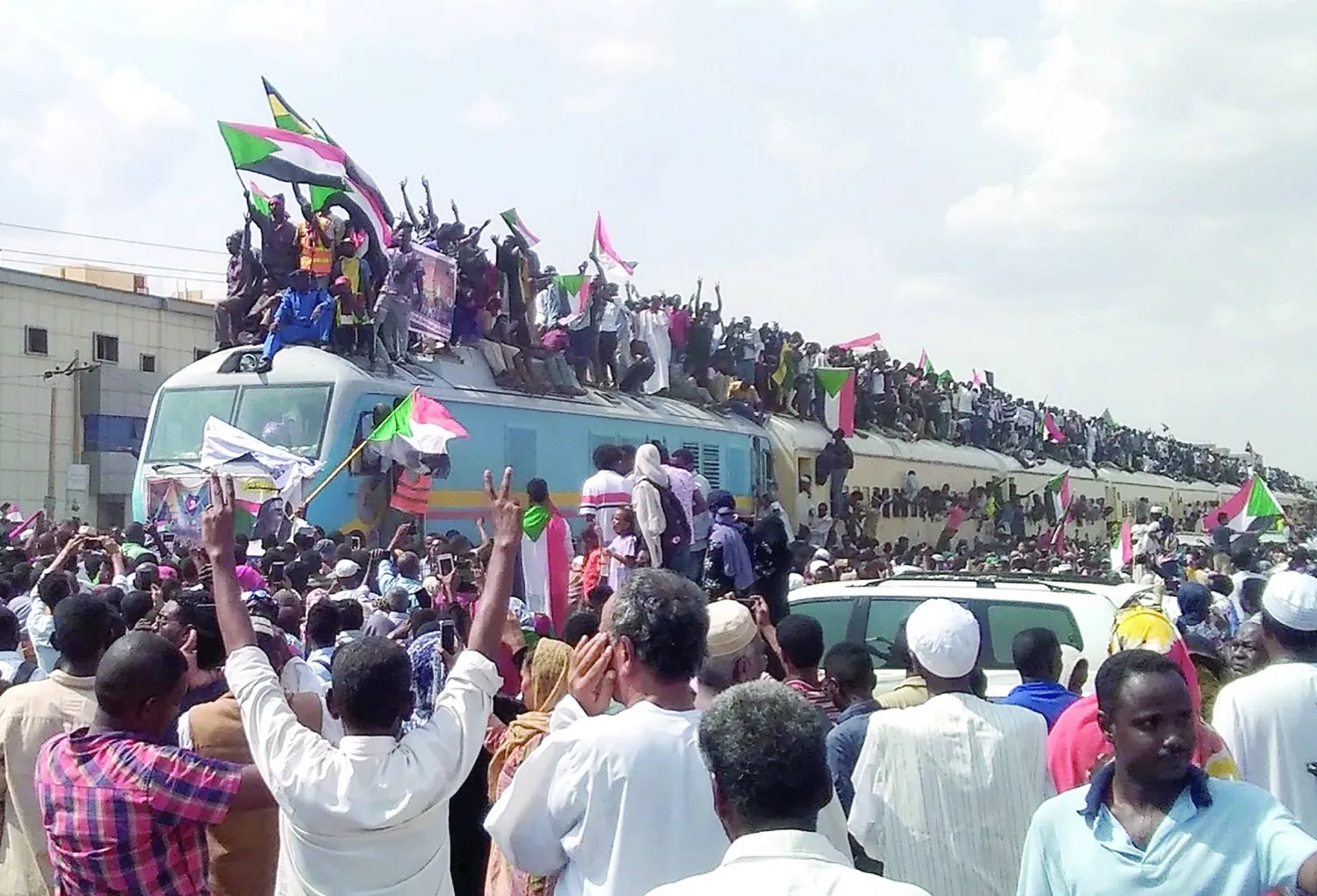 
سودانيون من محافظات أخرى يصلون إلى الخرطوم بالقطار للانضمام إلى الاحتفالات الشعبية بعد سقوط نظام البشير (إ.ب.أ)
