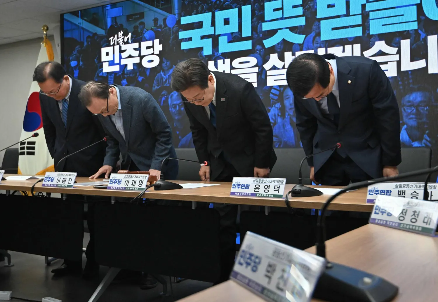 قادة الحزب الديموقراطي المعارض الذي يتزعمه لي جاي ميونغ (الثاني من اليمين) ينحنون شكرا للناخبين الذين صوتوا لصالح حزبهم (أ.ف.ب)